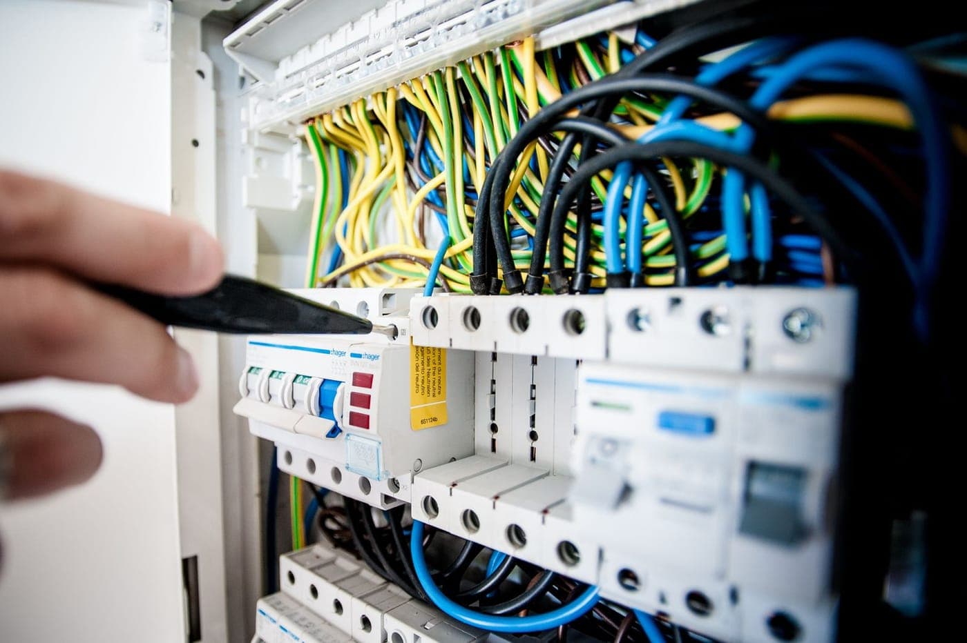 Electrician testing an open switchboard